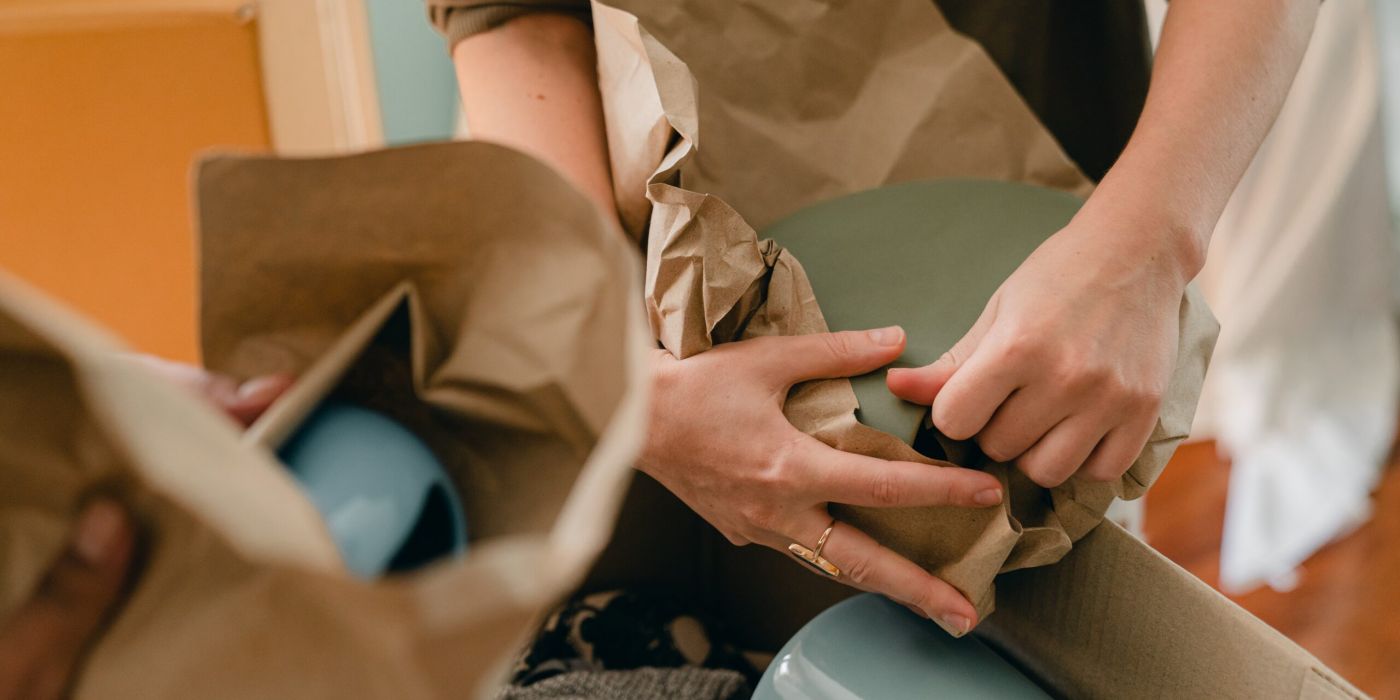 Hands packing cups in paper