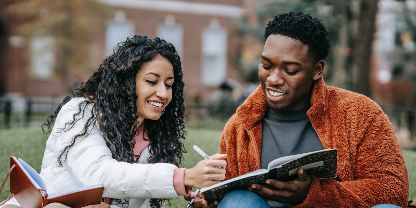 Two college aged students writing new year's resolutions.